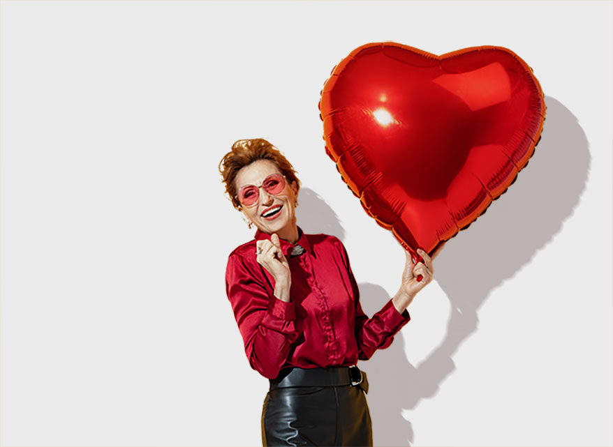 lady in red holding heart balloon