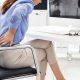 lady-sitting-on-office-chair-holds-lower-back