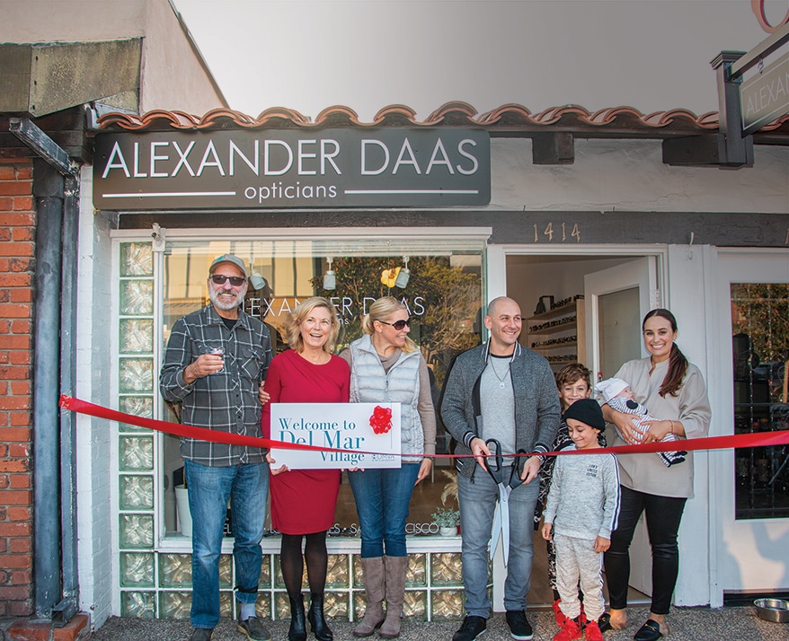Alexander Daas Eyewear & Opticians is just blocks from the beach in Del Mar, CA. Below, the city’s mayor (second from left) helps Alex Feldman (with scissors) and his wife Stephanie (right) open the location last year. 